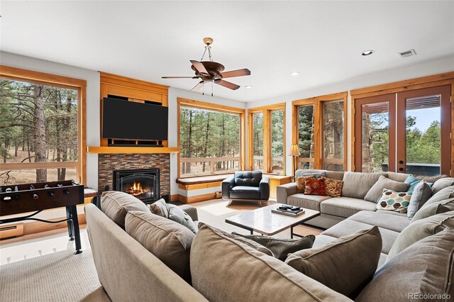 10231 Democrat Rd, Parker, CO 80134 - living room featuring healthy amount of natural light, a stone fireplace, a ceiling fan, and recessed lighting