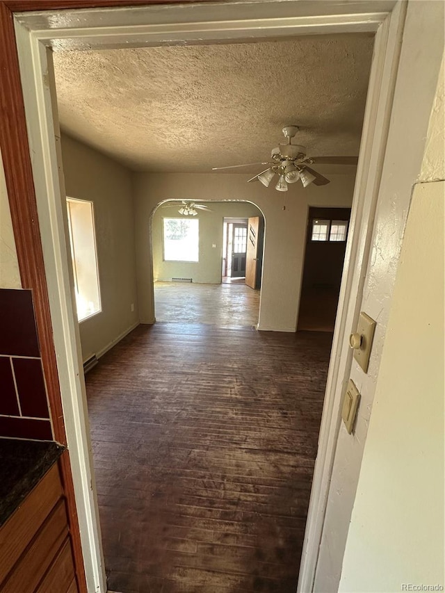 1114 La Due Ave, Alamosa, CO 81101 - interior space featuring arched walkways, dark wood-style floors, and a textured ceiling