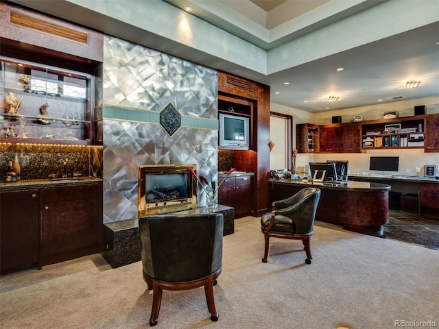 living room featuring light colored carpet and built in desk