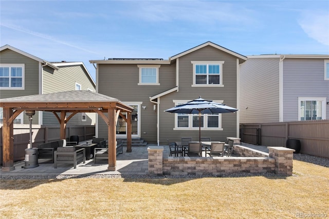 back of property featuring a gazebo, an outdoor hangout area, a patio, and fence