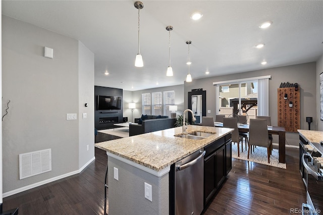 kitchen with visible vents, a sink, open floor plan, stainless steel appliances, and dark wood-style flooring