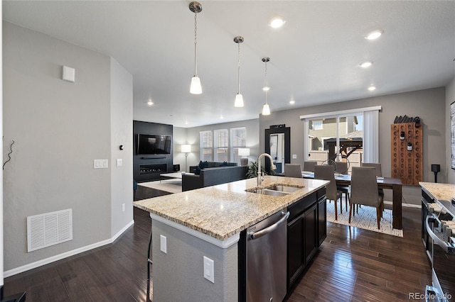 kitchen featuring plenty of natural light, open floor plan, visible vents, stainless steel appliances, and a sink