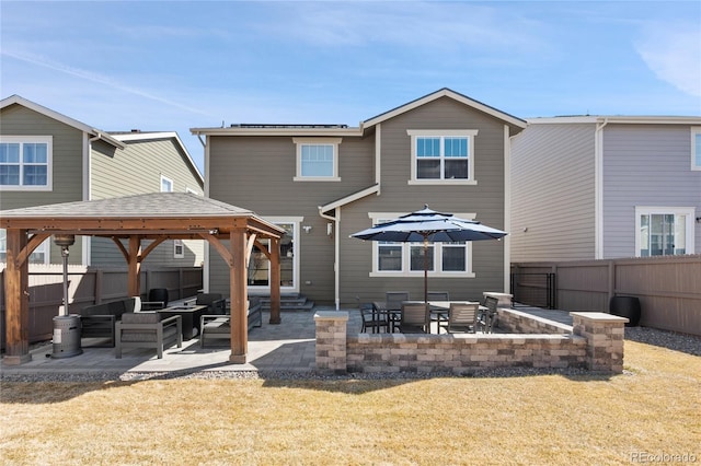 back of property featuring a fenced backyard, a yard, a patio area, an outdoor living space, and a gazebo