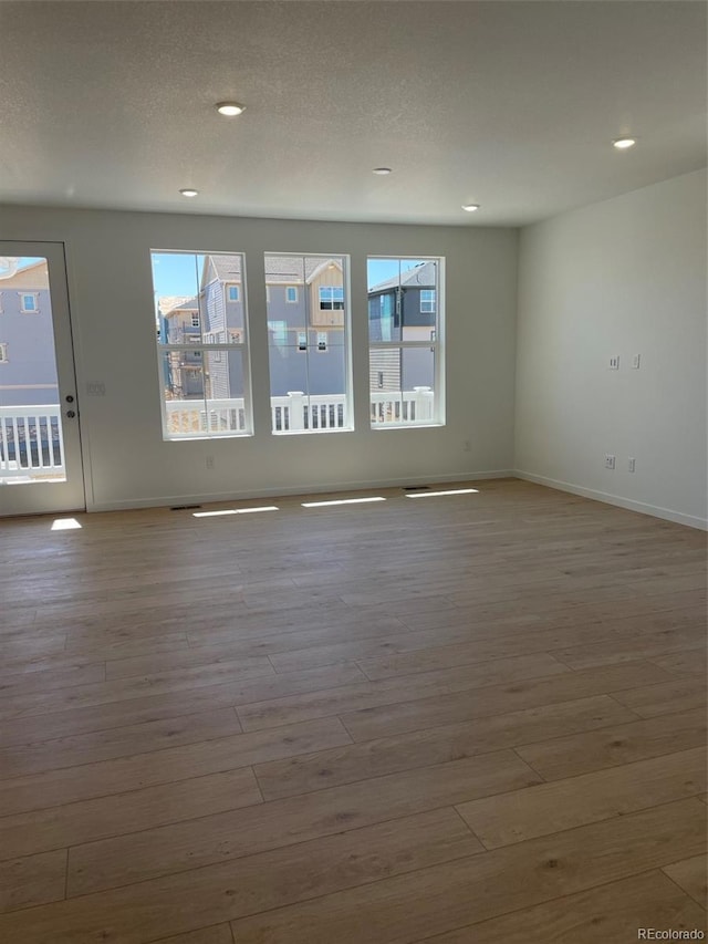 6657 E 149th Dr, Thornton, CO 80602 - empty room featuring wood finished floors, baseboards, recessed lighting, and a textured ceiling