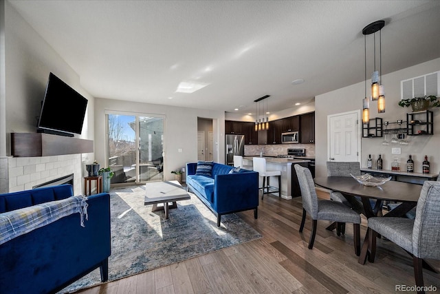 living room featuring recessed lighting, a fireplace, and wood finished floors