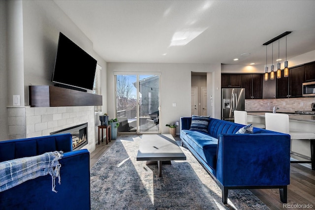 living area featuring light wood finished floors and a glass covered fireplace