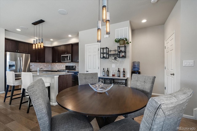 dining area featuring recessed lighting, baseboards, and light wood-style floors