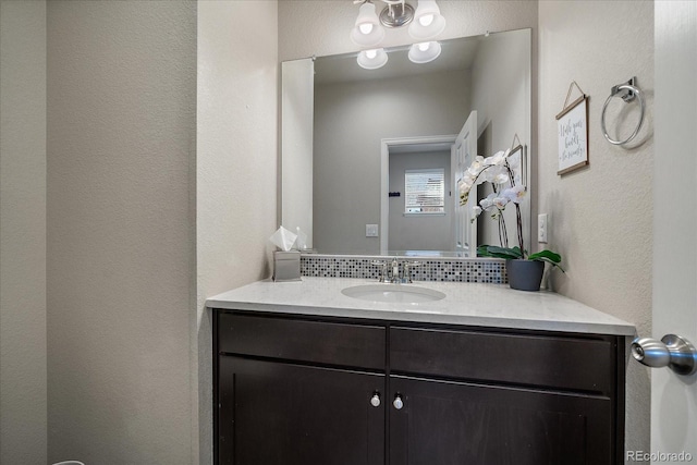 bathroom featuring vanity and a textured wall