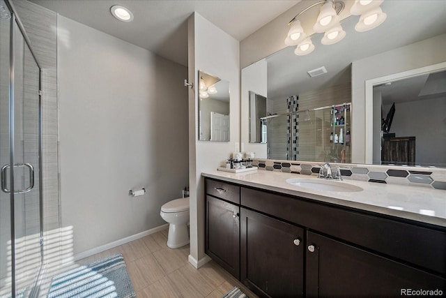 bathroom with visible vents, baseboards, toilet, a stall shower, and vanity