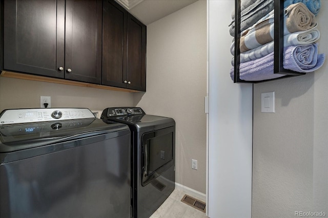 laundry area featuring baseboards, cabinet space, visible vents, and washing machine and clothes dryer