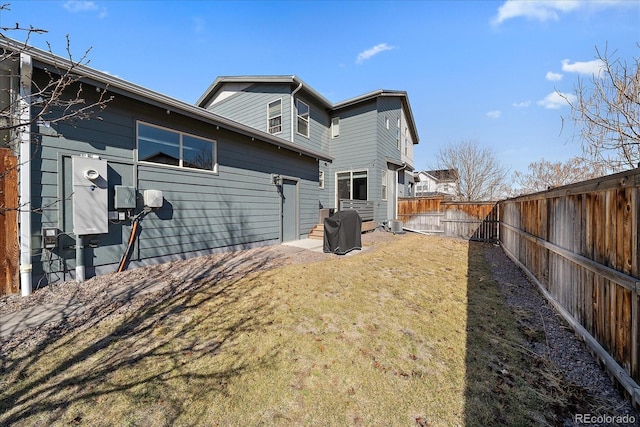 back of property featuring a yard and a fenced backyard