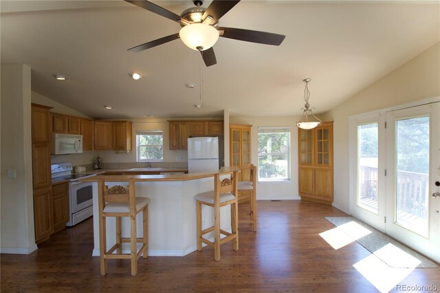 kitchen featuring dark wood-type flooring, white appliances, vaulted ceiling, ceiling fan, and a center island