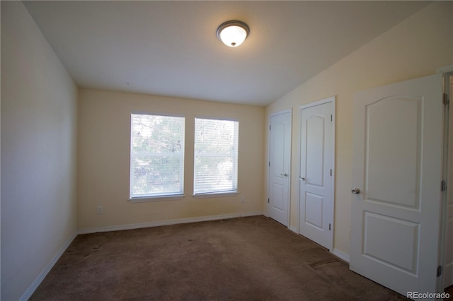 unfurnished bedroom featuring carpet and vaulted ceiling