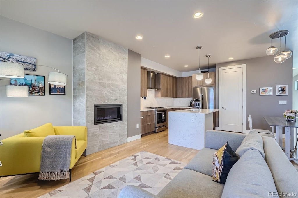 1439 Garfield St, Denver, CO 80206 - living area with a tiled fireplace, recessed lighting, and light wood-style flooring