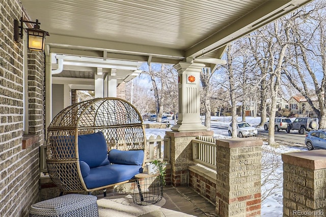 snow covered patio featuring a porch