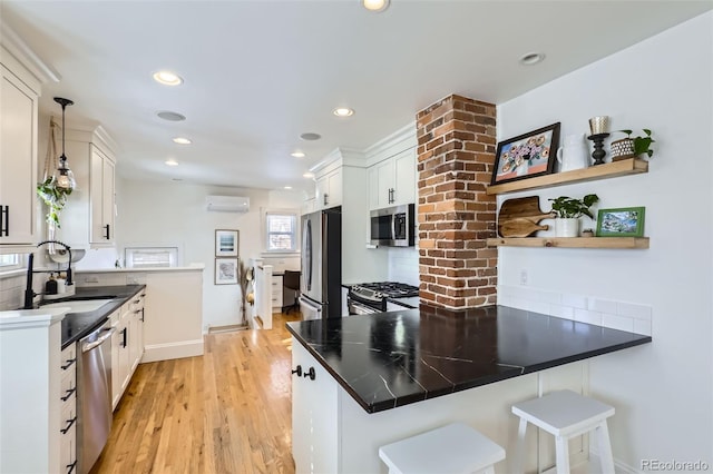 kitchen with kitchen peninsula, white cabinets, and appliances with stainless steel finishes