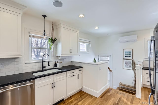 kitchen featuring sink, white cabinetry, decorative light fixtures, a wall mounted AC, and dishwasher