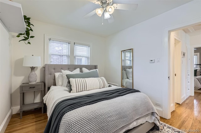 bedroom featuring a ceiling fan, baseboards, and light wood-type flooring