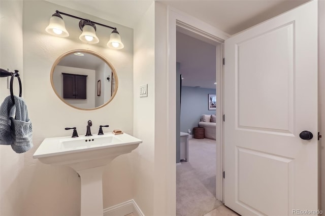 bathroom featuring baseboards and a sink