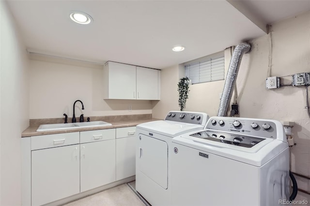 laundry room featuring separate washer and dryer, sink, and cabinets