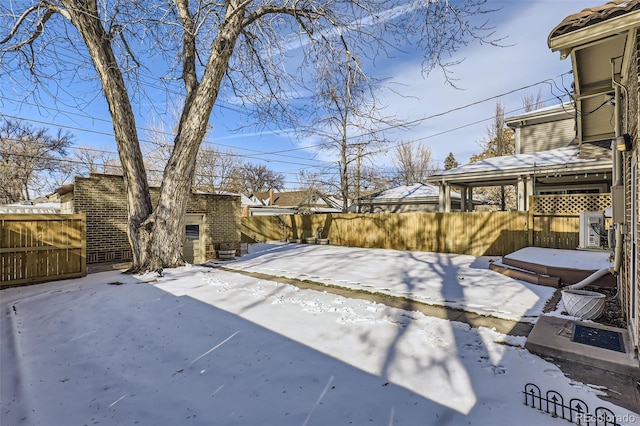 yard covered in snow featuring an outbuilding and a fenced backyard