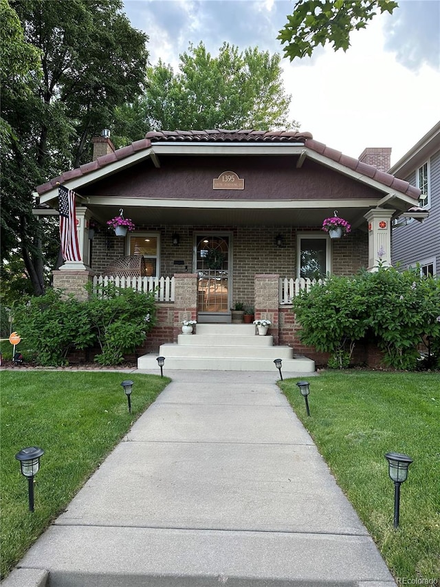 view of front facade featuring covered porch and a front lawn