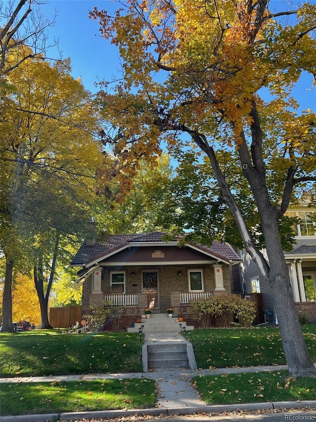 view of front of property with a front yard and covered porch