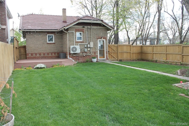 view of yard with a fenced backyard, ac unit, and central AC