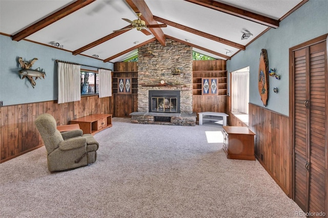 4960 S Fox St, Englewood, CO 80110 - carpeted living room with wooden walls, wainscoting, ceiling fan, a stone fireplace, and built in shelves