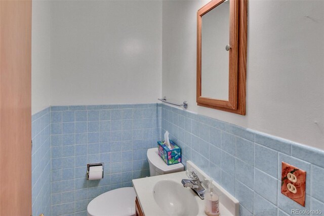 4960 S Fox St, Englewood, CO 80110 - bathroom featuring tile walls, toilet, wainscoting, and vanity