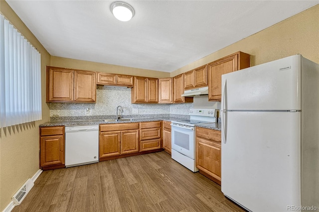 kitchen with white appliances, sink, light hardwood / wood-style floors, and backsplash