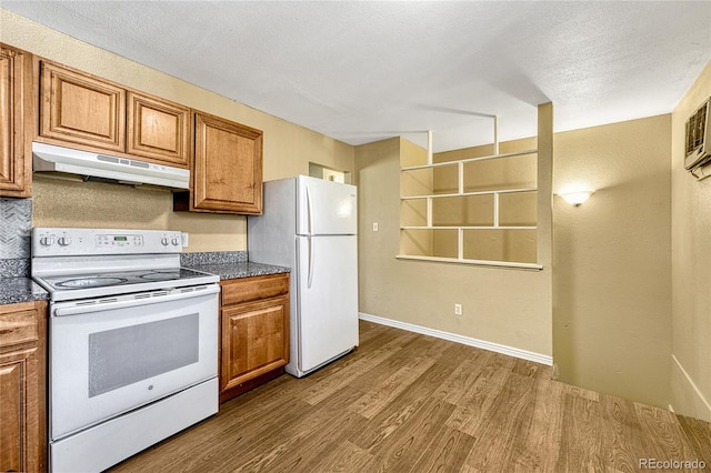 kitchen with dark wood-type flooring, white appliances, and a textured ceiling