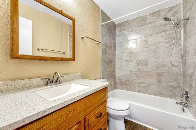 full bathroom featuring vanity, toilet, wood-type flooring, and tiled shower / bath combo