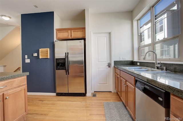 kitchen featuring stainless steel appliances, sink, and light wood-type flooring