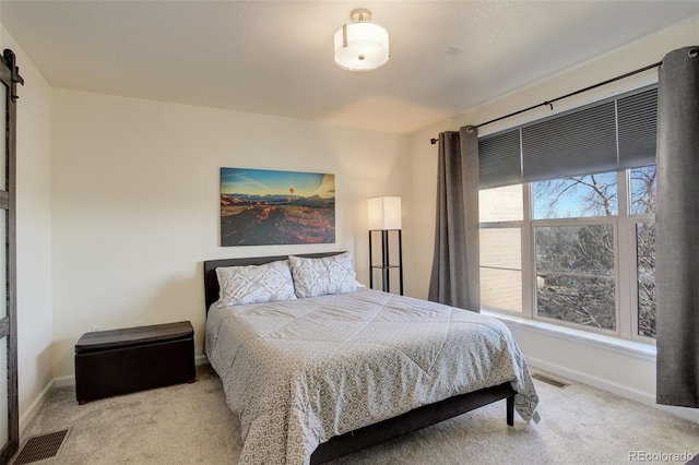 carpeted bedroom featuring a barn door