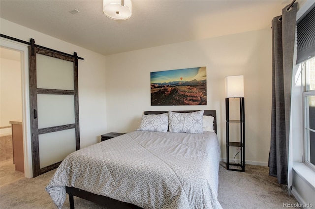 bedroom featuring a barn door and light carpet