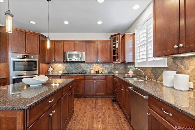 10840 Valleybrook Cir, Highlands Ranch, CO 80130 - kitchen featuring appliances with stainless steel finishes, dark wood-type flooring, glass insert cabinets, dark stone counters, and recessed lighting