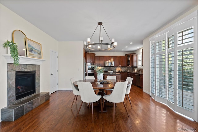10840 Valleybrook Cir, Highlands Ranch, CO 80130 - dining room with dark wood-style flooring, a chandelier, a tile fireplace, and recessed lighting