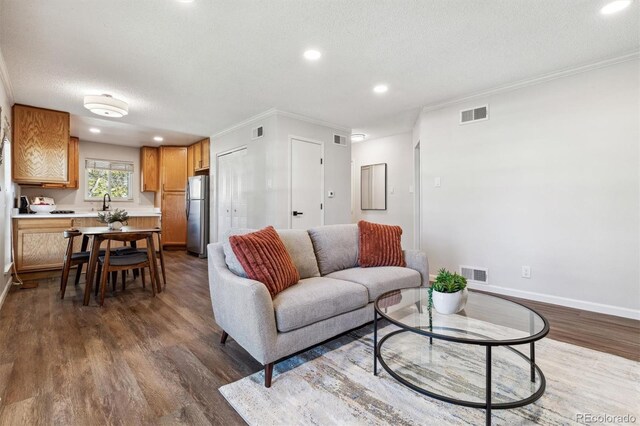 living area with dark wood-style floors, visible vents, and a textured ceiling