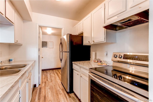 kitchen featuring sink, white cabinetry, light stone counters, stainless steel appliances, and light hardwood / wood-style floors