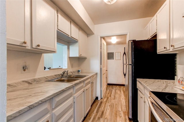 kitchen with white cabinetry, sink, light hardwood / wood-style floors, light stone countertops, and electric stove