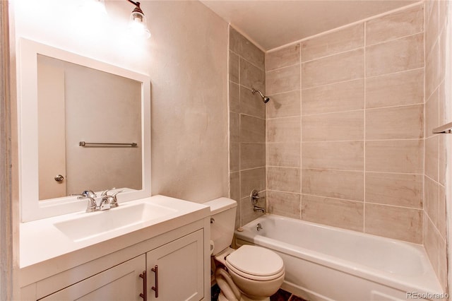 full bathroom with tiled shower / bath, vanity, and toilet