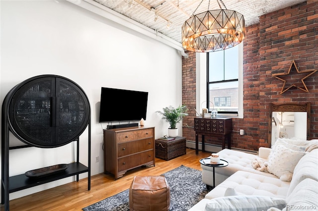 2261 Blake St Unit 2G, Denver, CO 80205 - living area featuring a chandelier, wood finished floors, brick wall, and a high ceiling