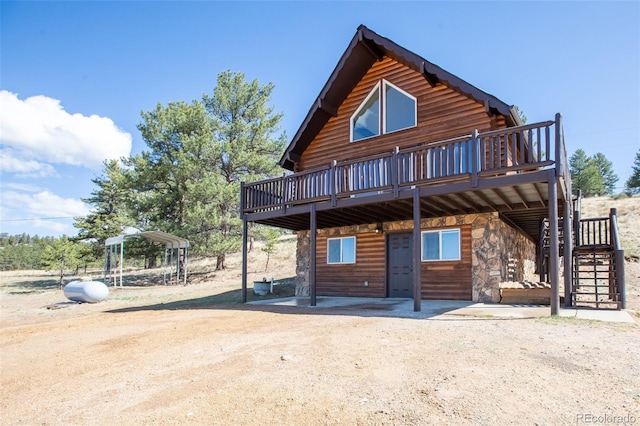 view of front facade with a deck, stairs, and stone siding