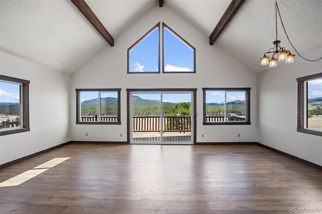 unfurnished living room with a textured ceiling, beam ceiling, wood finished floors, high vaulted ceiling, and an inviting chandelier