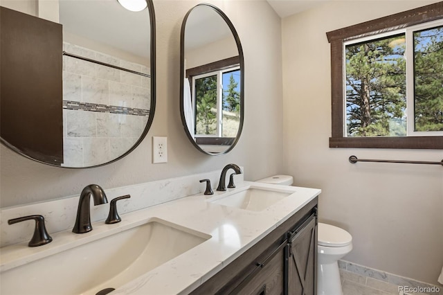 full bath with double vanity, toilet, tile patterned floors, and a sink