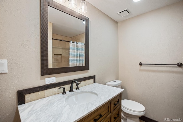 full bathroom with visible vents, vanity, toilet, a textured wall, and a shower with shower curtain