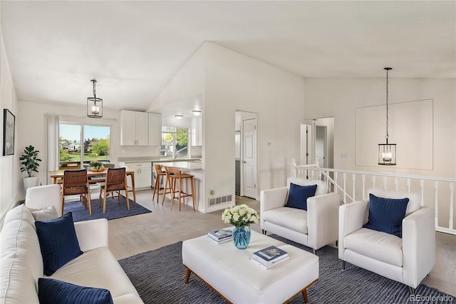 living room featuring vaulted ceiling and a chandelier