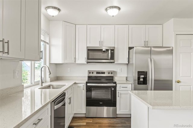 kitchen with stainless steel appliances, a sink, and white cabinets