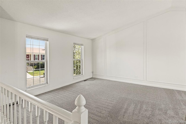 carpeted spare room featuring a decorative wall